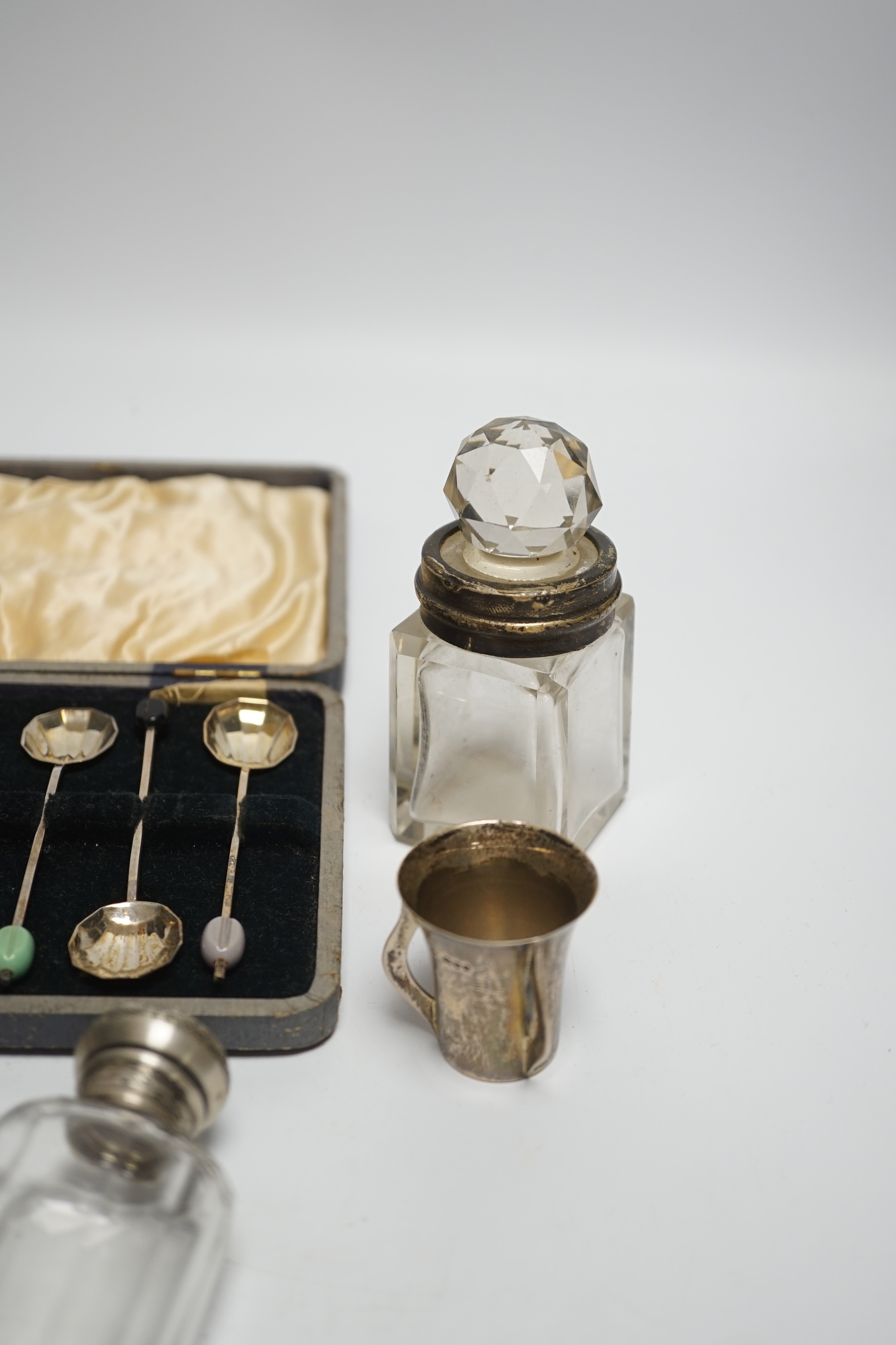 A Hanau silver novelty figural pepperette and other small silver including a silver mounted hand mirror, scent bottles and a small tyg and a cased set of plated spoons.